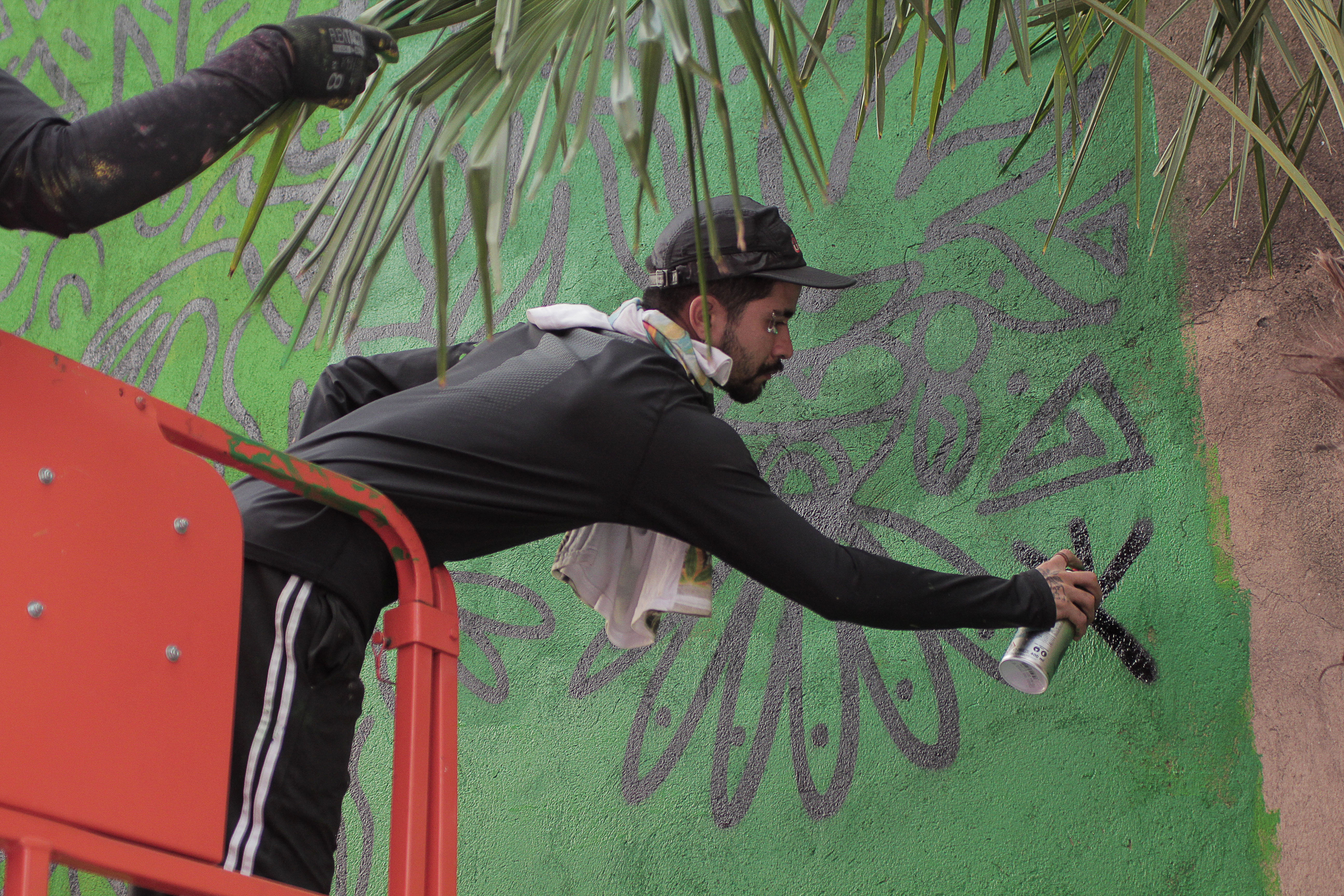 O artista pintando o mural em São Paulo